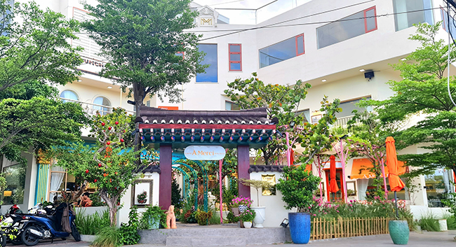 À Merci Coffee & Burch được bao quanh bởi cây xanh và các khu vườn hoa